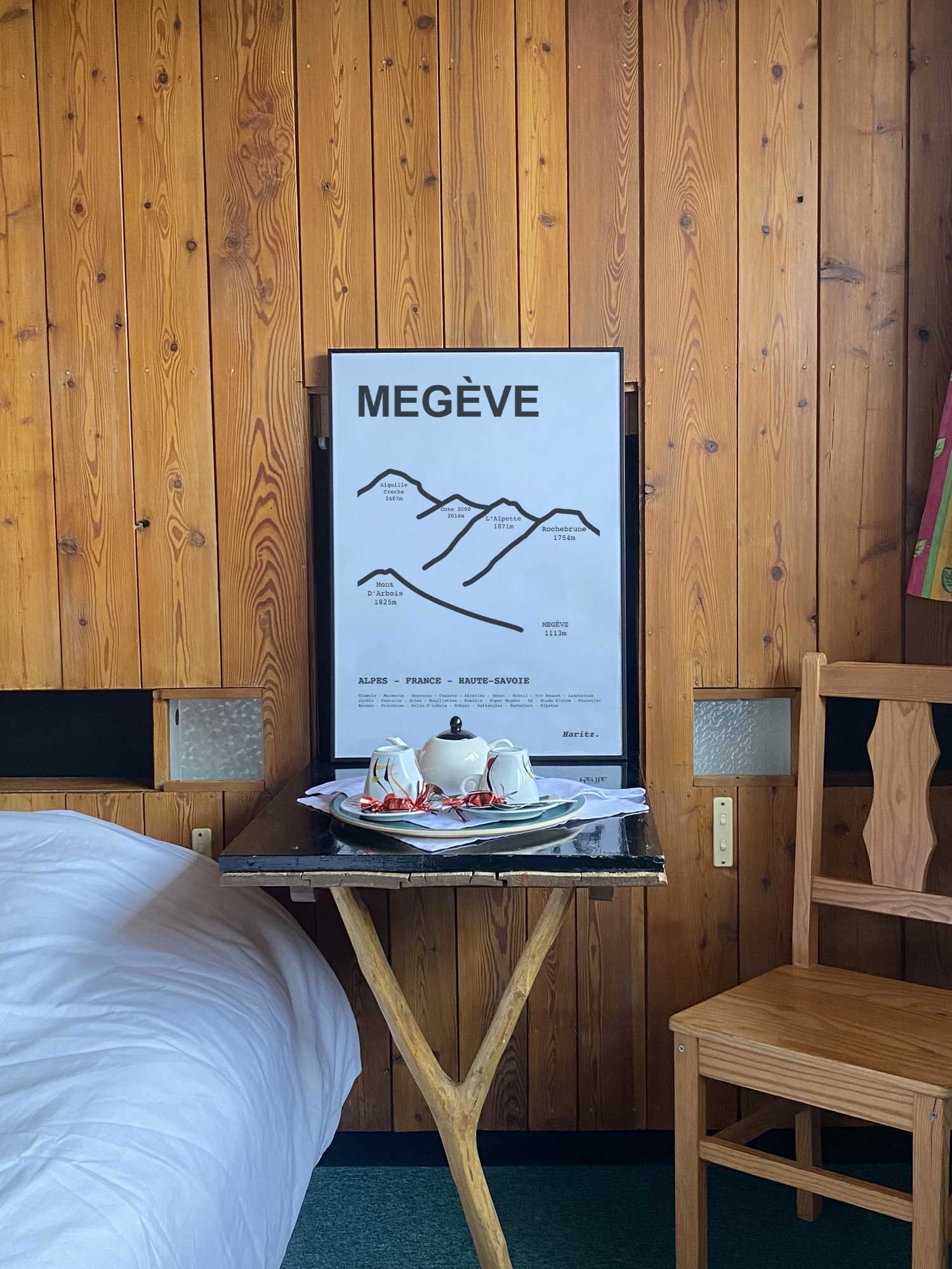 Affiche Megève du tracé des sommets encadrée dans une chambre d’hôtel de montagne en bois, décoration murale style chalet par Haritz.