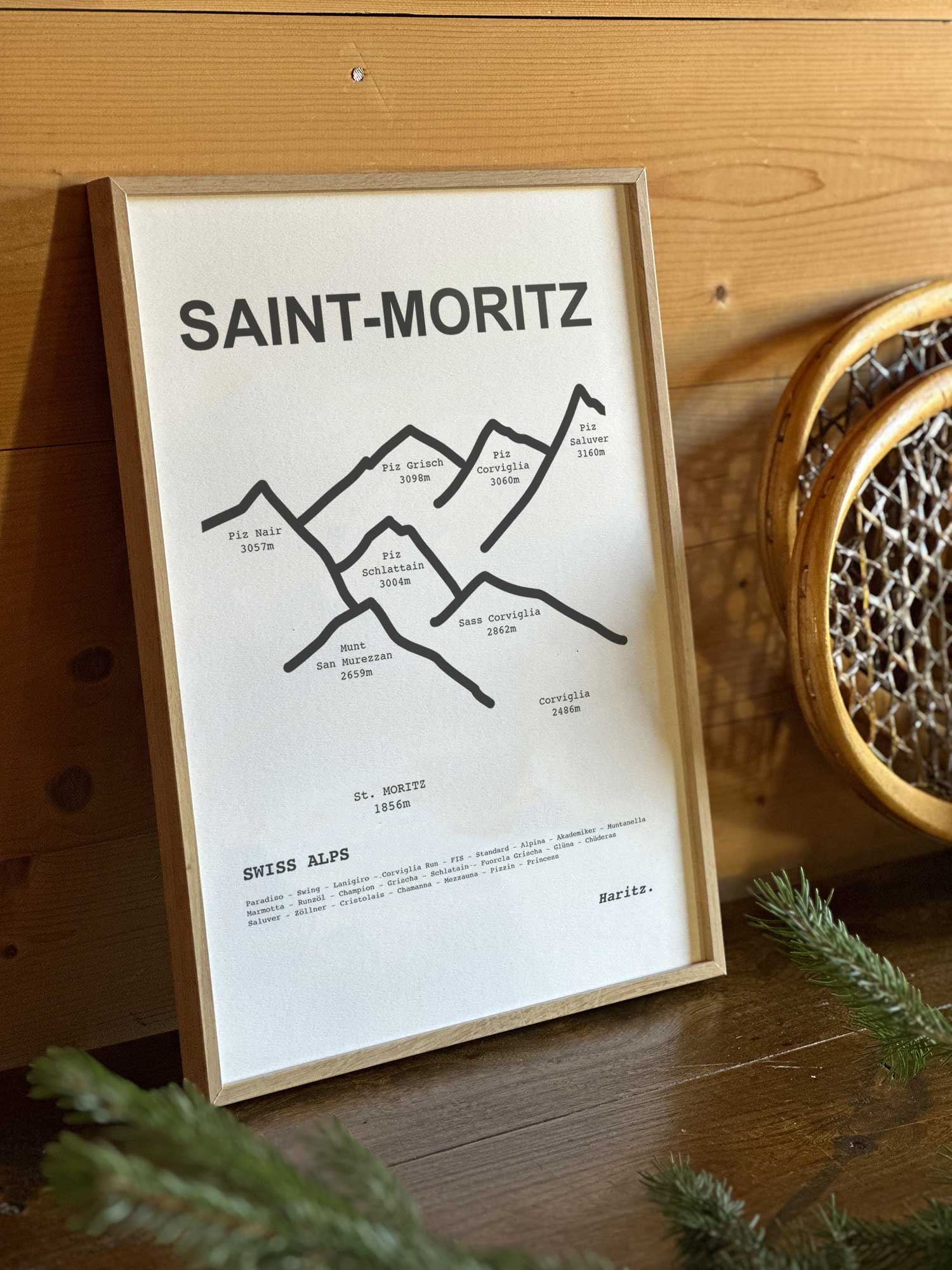 Affiche Saint-Moritz du tracé topographique des sommets dans un cadre en bois naturel, mise en scène dans une décoration chalet avec objets vintage et raquettes à neige, par Haritz.