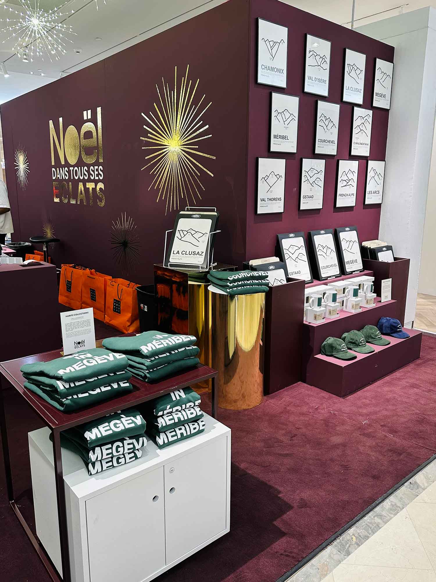 Boutique Haritz Collections au Bon Marché pour l'événement Noël dans tous ses éclats — affiches des stations de ski des Alpes, sweats Megève et Méribel, mugs et casquettes